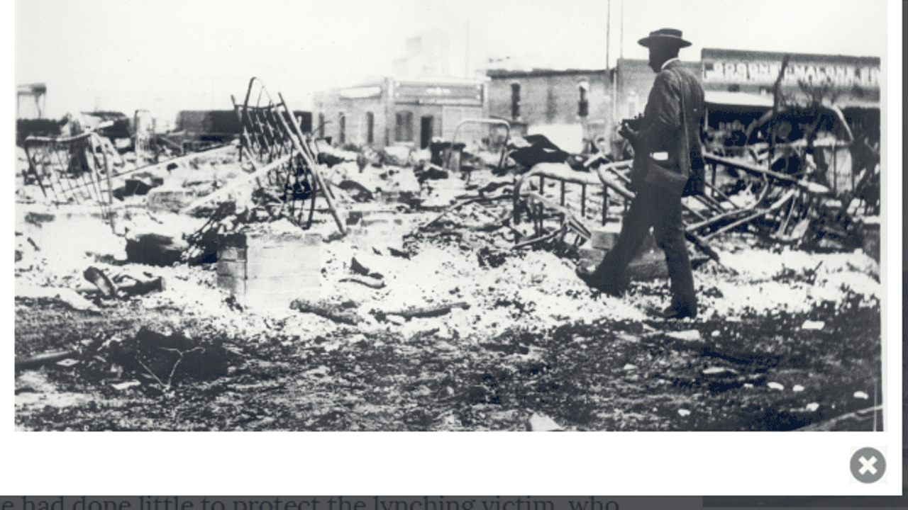 Man inspects extensive fire damage at a building site.