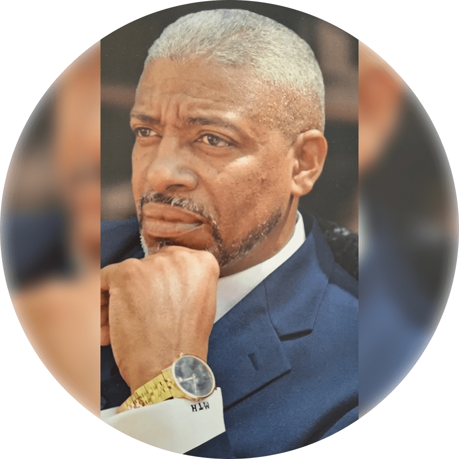 Thoughtful man in a suit resting his chin on his hand.
